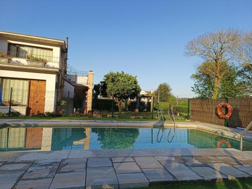 een zwembad voor een huis bij A Solaina da Bouza in Cambados