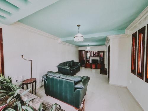 a living room with two green leather couches at Diamantina Palace Hotel in Morro do Chapéu