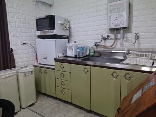 uma cozinha com um lavatório e um micro-ondas em Lapus Honmachi No.200 / Vacation STAY 57908 em Hikone