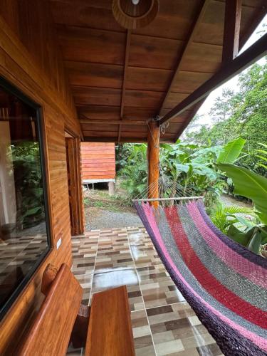 a hammock on the porch of a house at Arenal Rústic Lodge in Fortuna