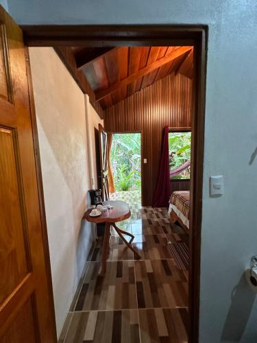 a hallway with a table and a door to a room at Arenal Rústic Lodge in Fortuna
