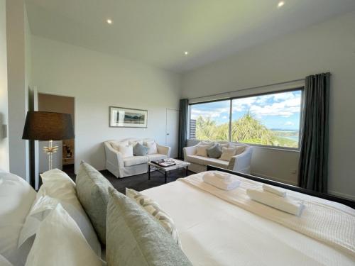 un soggiorno con divano bianco e una grande finestra di Delamore Cove - Karaka - Waiheke Escapes a Matiatia Bay