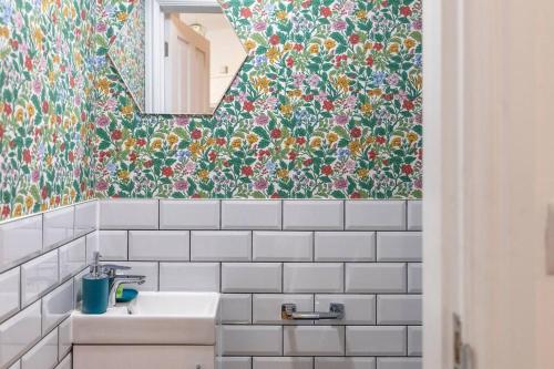 een badkamer met een spiegel en een witte wastafel bij City Comforts Spacious 1BR with Furnished Kitchen in Londen