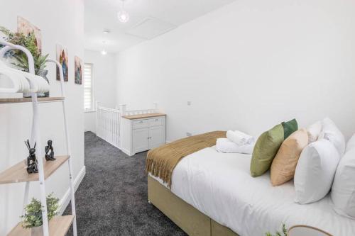 een witte slaapkamer met een bed en een bureau bij City Comforts Spacious 1BR with Furnished Kitchen in Londen