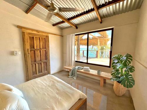 a bedroom with a bed and a window and a plant at Casa Costa Salvaje in El Gigante