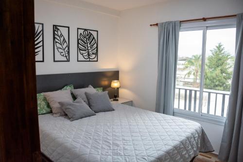 a bedroom with a bed and a large window at Centro Apart Home in Jesús María