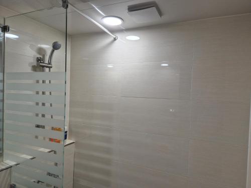 een badkamer met een douche met witte muren bij Gwang Jang Hotel in Busan
