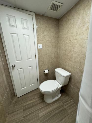 a bathroom with a white toilet and a door at Super 8 by Wyndham Corpus Christi Airport in Corpus Christi