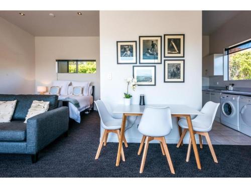 un salon avec un canapé, une table et des chaises dans l'établissement Delamore Cove - Kauri - Stay Waiheke, à Matiatia Bay