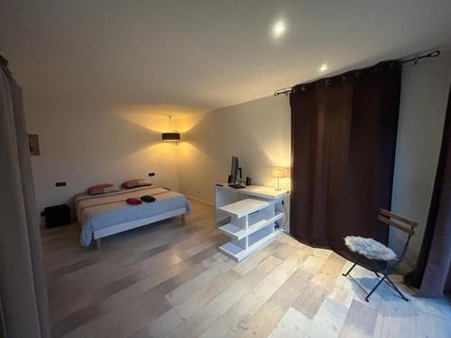 une chambre avec un lit, une table et une chaise dans l'établissement Intime et tranquille, à Vernouillet