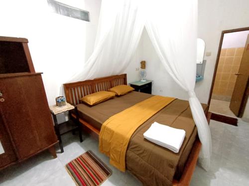 a bedroom with a bed with a canopy at Jojo's Warung & Homestay in Munduk