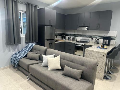a living room with a couch and a kitchen at Hermoso Apartamento para 2 personas, a 10 min en vehículo del Zócalo de Oaxaca in Oaxaca City