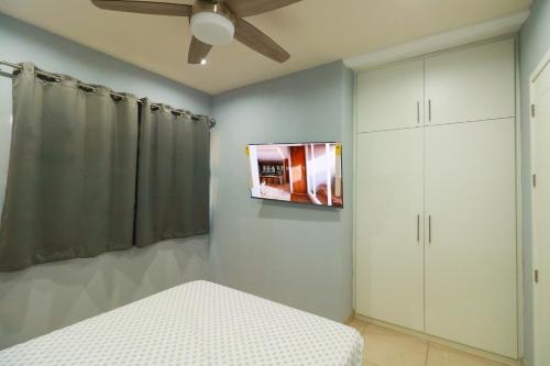 a bedroom with a bed and a tv on the wall at Hermoso Apartamento para 2 personas, a 10 min en vehículo del Zócalo de Oaxaca in Oaxaca City