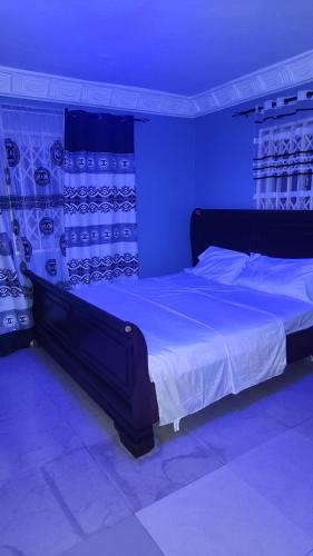 - une chambre avec un grand lit et un éclairage bleu dans l'établissement Royal Island Breeze Resort SL, à Freetown