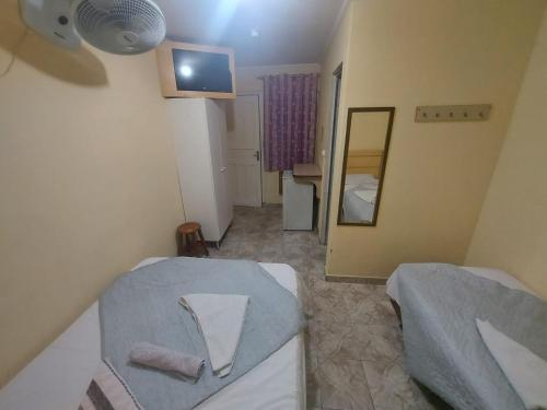 a small room with a bed and a mirror at Hotel Mooca in Sao Paulo