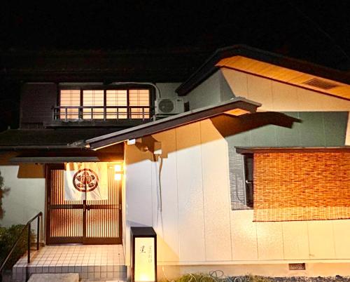 a house with a lit up front door at night at 内宮前別邸星宮 in Uji