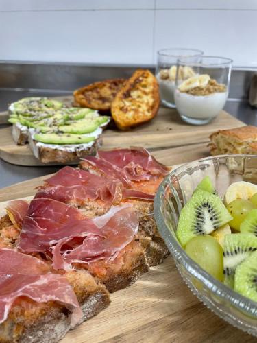 einen Tisch mit einem Haufen verschiedener Brotsorten und Obst in der Unterkunft HOTEL BOUTIQUE VILAVELLA in O Grove