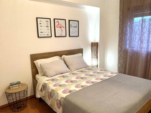 a bedroom with a bed and three pictures on the wall at Apartamento Fonte Velha in Nazaré