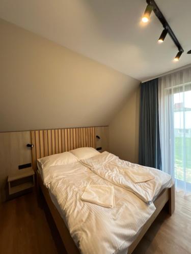 1 dormitorio con 1 cama blanca y ventana en Willa Olimpia, en Podzamcze