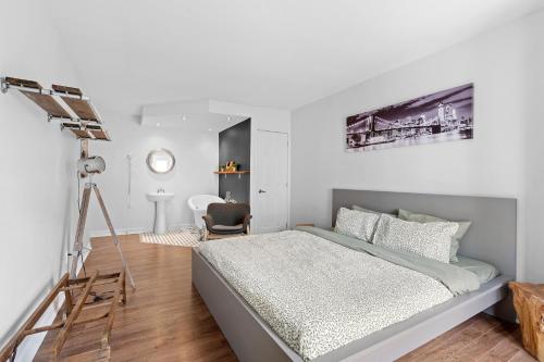 a white bedroom with a bed and a desk at The redbull lodge with parking in Quebec City