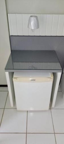 a white table with a lamp on top of a trash can at Gran Lençóis Flat Barreirinhas Apt 509 in Barreirinhas