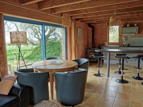 un salon avec une table et des chaises et une fenêtre dans l'établissement Stone House near Rosa Granite Coast, à Bas Kerhain