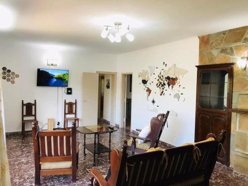 a living room with a couch and a table at Excelente y amplio Chalet Capacidad 2 a 6 personas, La mejor ubicación de la Falda, Barrio Residencial Villa Edén, A tan solo 3 cuadras del hotel Edén y a pasos del centro de dicha localidad - Cámaras de seguridad 24hs - unidad Monitoreada in La Falda