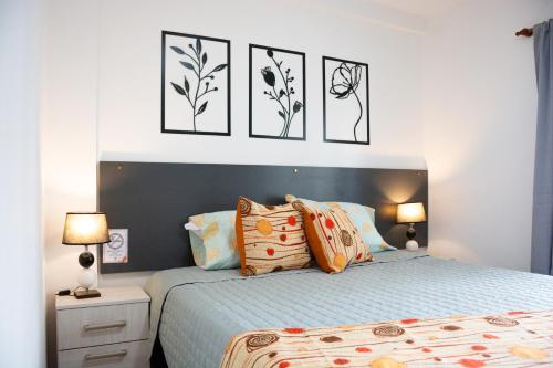 a bedroom with a bed with four pictures on the wall at Centro Apart Home in Jesús María