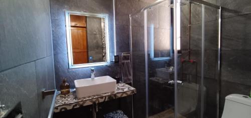 a bathroom with a sink and a shower and a mirror at Casa Tapanco Tepoztlán in Tepoztlán
