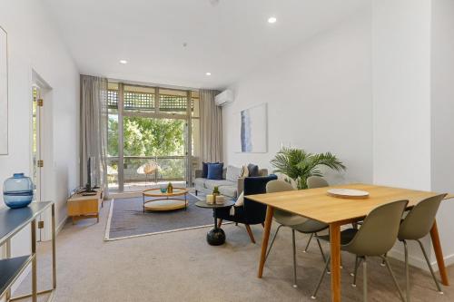 uma sala de estar com uma mesa e um sofá em Hobson Quay Apartments by Urban Rest em Auckland