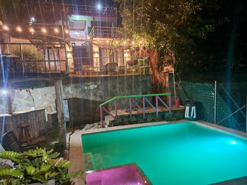 a swimming pool in a backyard at night at Restaurante y Hostal Romayor in El Congo