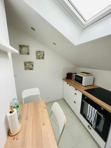 une cuisine avec une table en bois et un micro-ondes dans l'établissement Appartement charmant et lumineux, à Villejuif