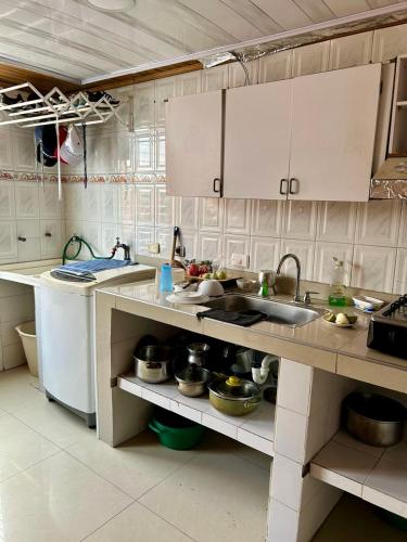 a kitchen with white cabinets and a sink at El pinar, Dindalito in Bogotá