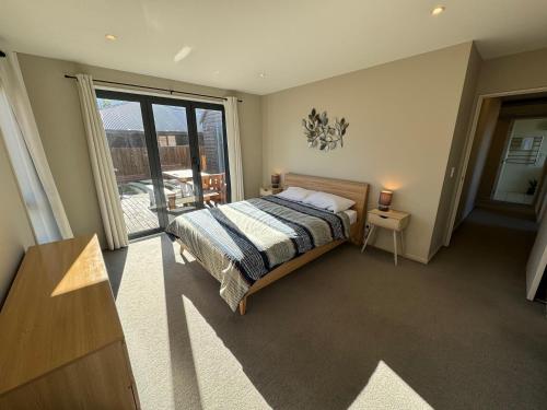 a bedroom with a bed and a large window at 7a Coleridge Street in Hanmer Springs