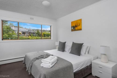 Un dormitorio blanco con una cama y una ventana. en Sandy Bay Waterfront, en Sandy Bay