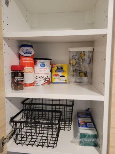 a refrigerator shelf with food and other food items at Cozy vacation! 3min from Cinema Plex, Biggest YMCA, South Health Campus, etc in Calgary