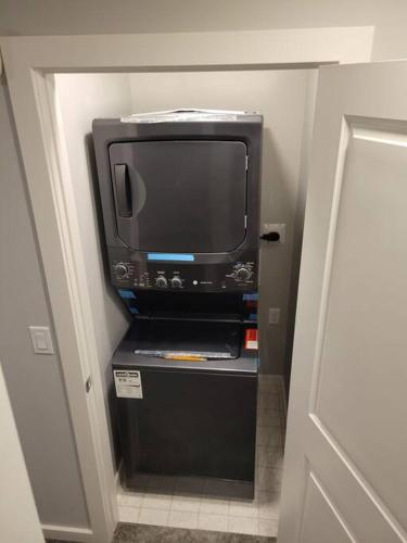 a tv sitting on a shelf in a hallway at Cozy vacation! 3min from Cinema Plex, Biggest YMCA, South Health Campus, etc in Calgary