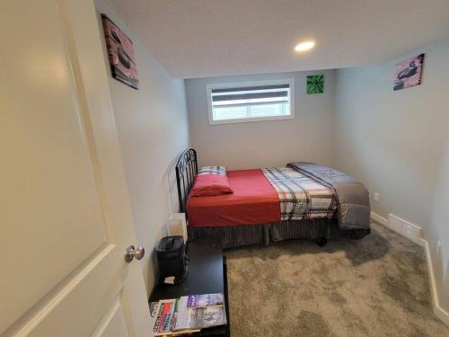 a small bedroom with a small bed in a room at Cozy vacation! 3min from Cinema Plex, Biggest YMCA, South Health Campus, etc in Calgary