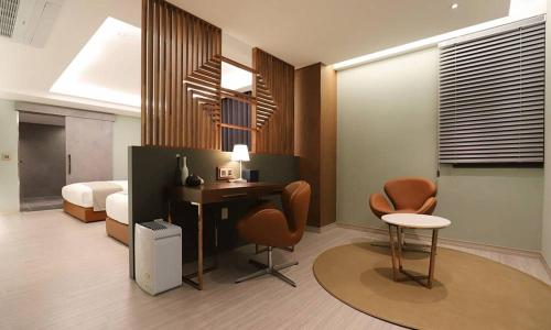 Pokój z biurkiem, 2 krzesłami i łóżkiem w obiekcie Dongdaegu Station Eastern Hotel w mieście Daegu