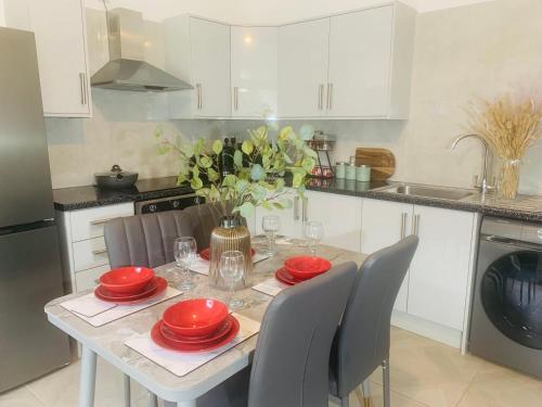 uma cozinha com uma mesa com placas vermelhas em WHOLE HOUSE, Near Bury Town Centre Manchester , 3 Bedrooms, 3 En-suite House, Free Parking, Wi-Fi, Sleeps 5 em Bury