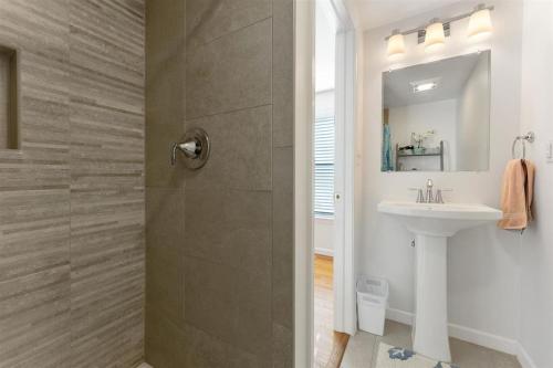 uma casa de banho branca com um chuveiro e um lavatório. em Cozy and Quiet- Seaview Avenue in Wildwood Crest em Wildwood