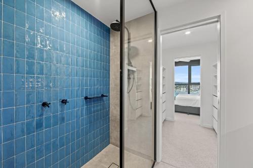 a bathroom with a shower with blue tiles at Fortitude Valley Apartments by CLLIX in Brisbane