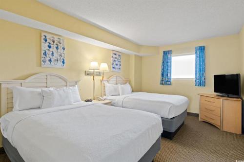 a hotel room with two beds and a television at North Myrtle Beach 1BR Oceanfront Condo at Bay Watch in Myrtle Beach
