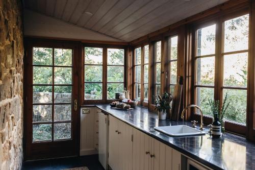 a kitchen with windows and a counter with a sink at Waterfalls in Basket Range