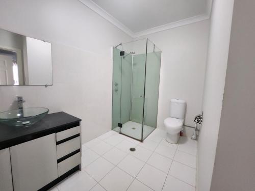 a bathroom with a glass shower and a toilet at Unit 26 Seafront Estate in Jurien Bay