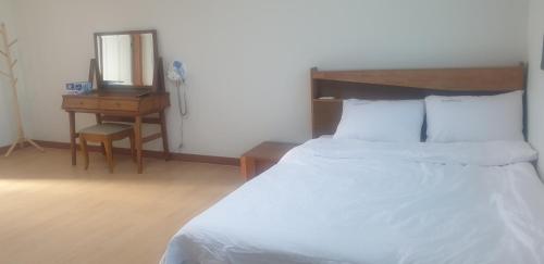 a bedroom with a bed and a desk and a mirror at 더드림하우스 in Jeonju
