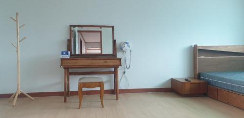 a dressing table with a mirror and a stool in a room at 더드림하우스 in Jeonju