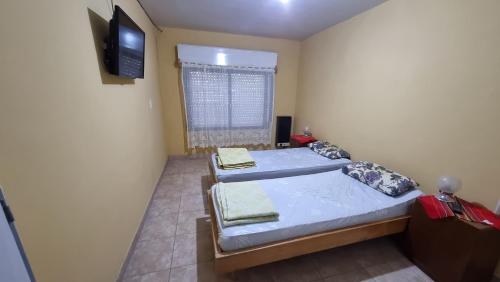 two beds in a room with a flat screen tv at Departamento El Membrillo in Valle