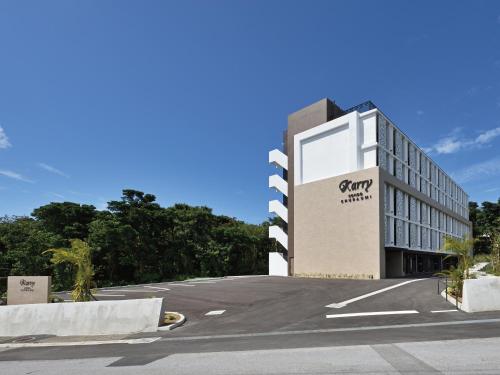 een gebouw met een bord aan de kant van een weg bij Karry CONDO CHURAUMI in Motobu