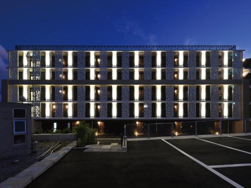 a large building with lights in a parking lot at Karry CONDO CHURAUMI in Motobu